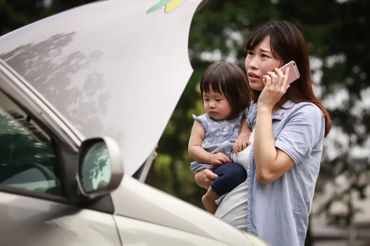 車の故障で困り電話をかけている女性